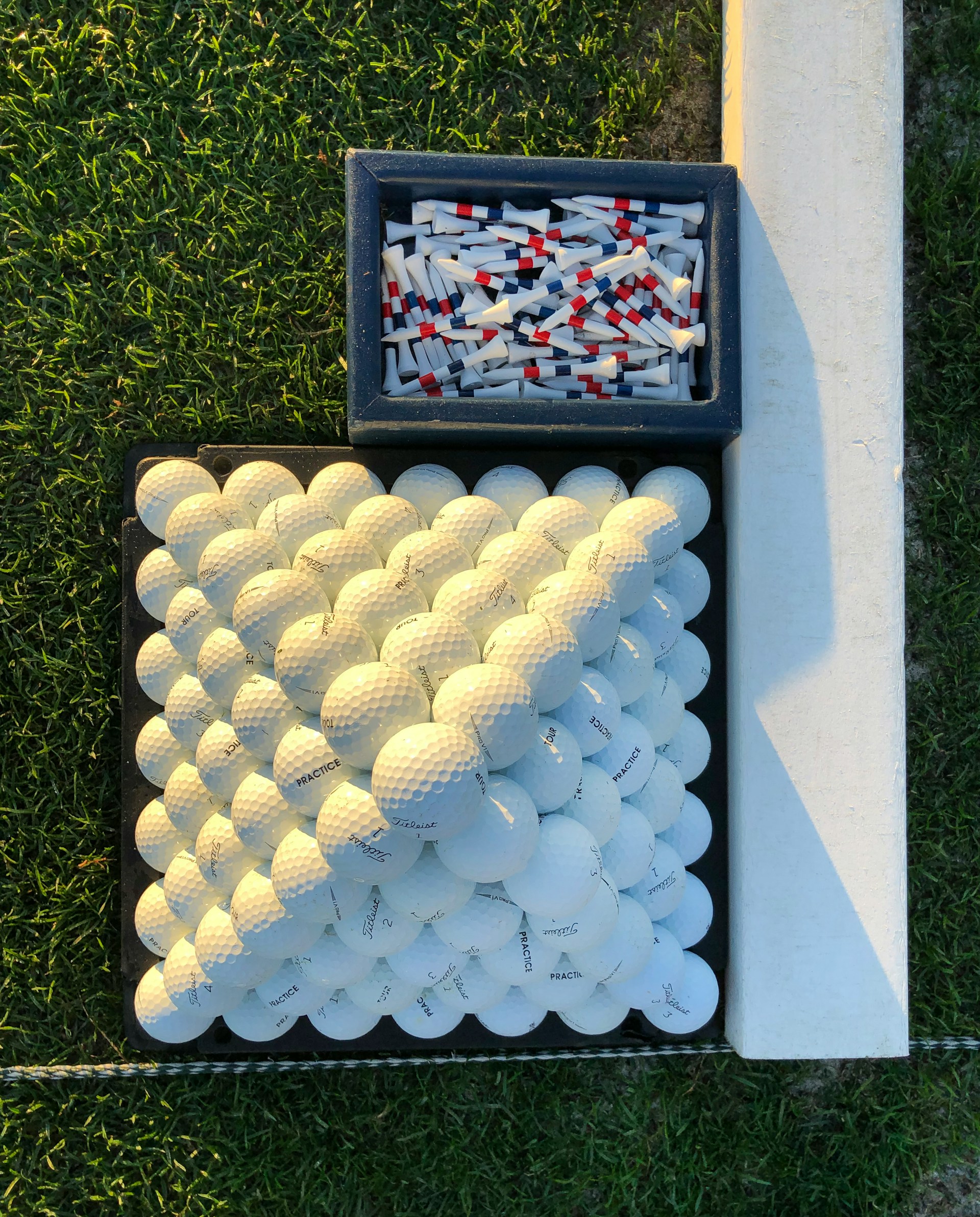 Titleist practice balls and tees at a driving range