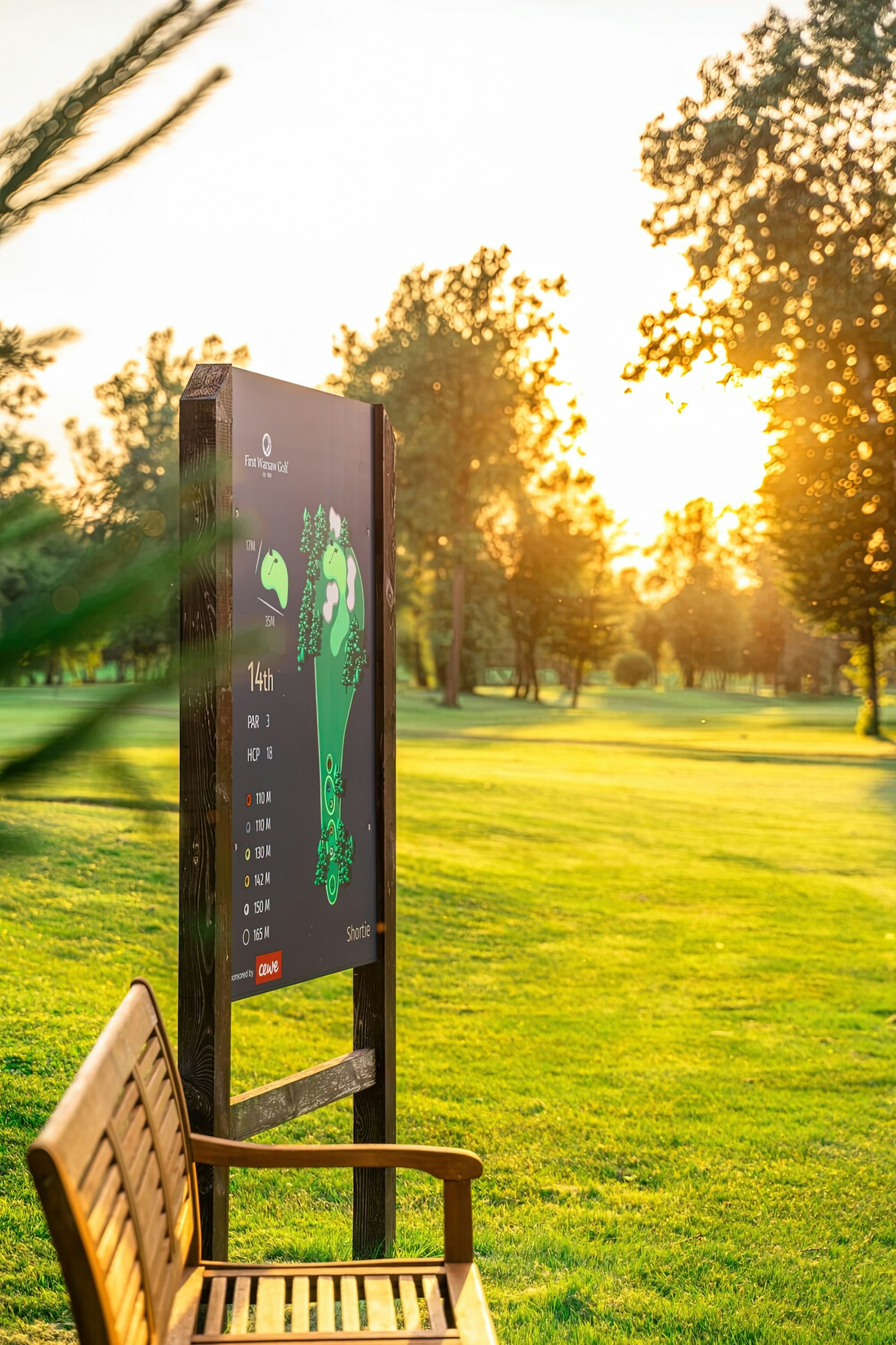 Golf course hole signboard showing par and handicap information at golden hour
